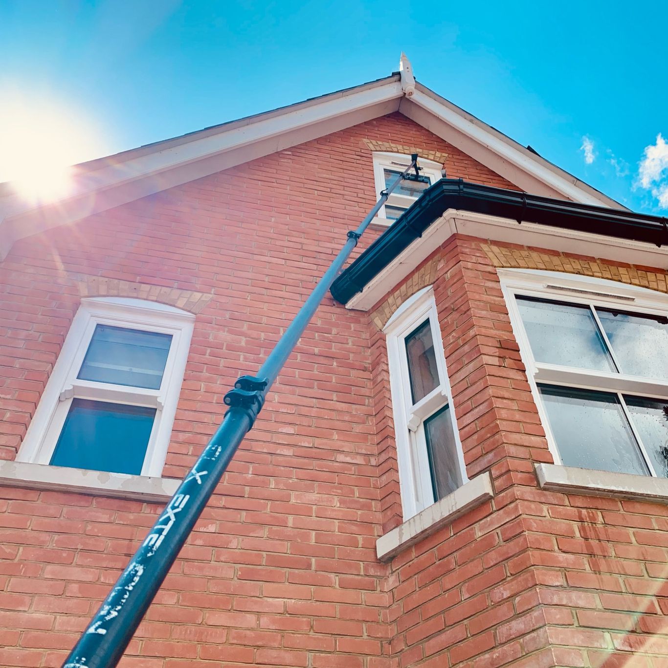 Water fed pole cleaning third storey residential window in Englefield Green