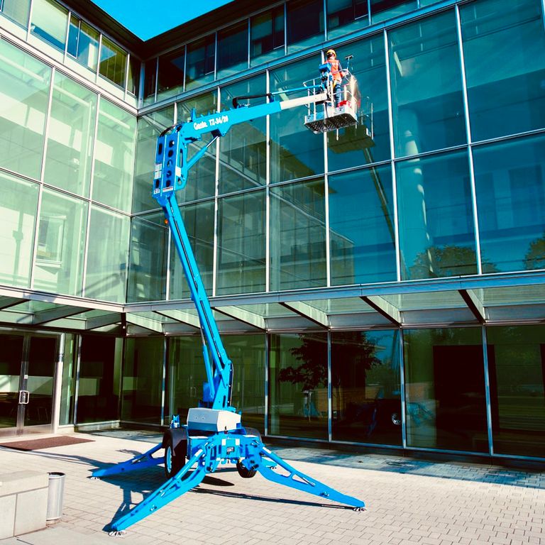 Aquatek team cleaning office building in Egham using access equipment